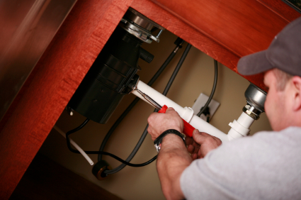 plumber in Boulder repairs a garbage disposal